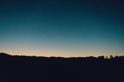 Silhouette landscape against clear sky during sunset