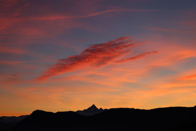 Silhouette mountain against dramatic sky during sunset