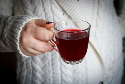 Midsection of woman holding wineglass