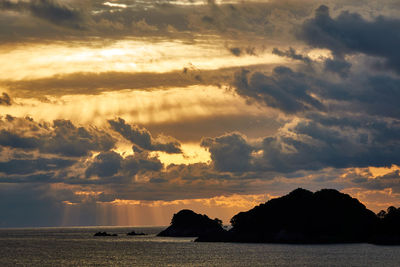 Scenic view of sea against dramatic sky during sunrise