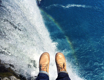 Low section of person standing in water