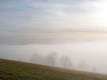 Scenic view of field against sky during foggy weather