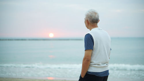 Man standing at beach against sky