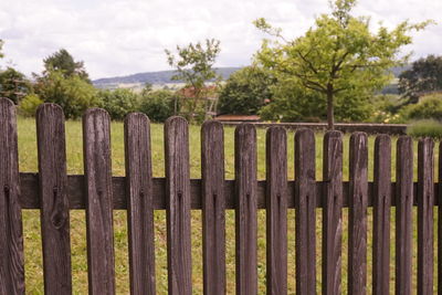 Wooden fence on field against sky