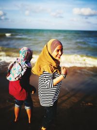 Rear view of women on beach against sea