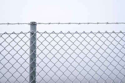 Low angle view of chainlink fence against sky