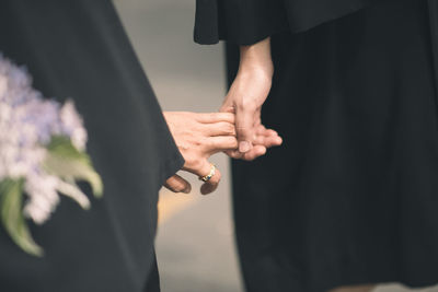 Midsection of couple holding hands