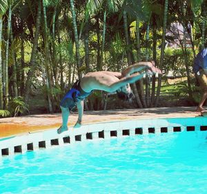 Woman jumping in swimming pool