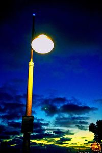 Low angle view of illuminated street light against sky