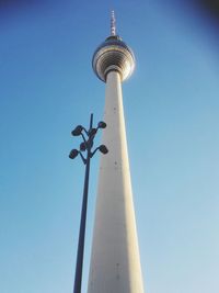 Low angle view of communications tower against blue sky