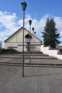 Low angle view of street light by building against sky