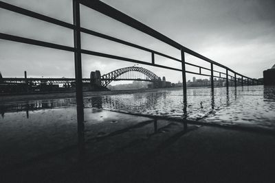 Bridge over river in city against sky