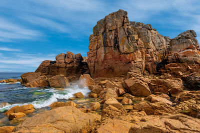 Rock formations in sea against sky