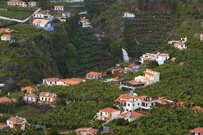 View from miradouro da torre viewpoint of a village in madeira with a waterfall