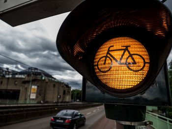 Close-up of road signal against illuminated city