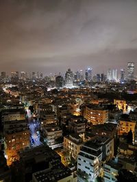 High angle view of illuminated buildings against sky at night