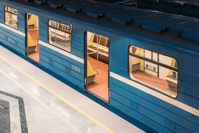 Blue subway wagon with yellow light inside stay at the empty platform and wait passengers. 