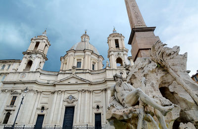 Low angle view of statues on building against sky