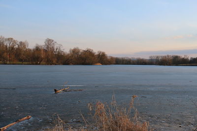 Scenic view of lake against sky during winter