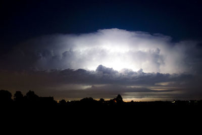 Silhouette landscape against sky at night