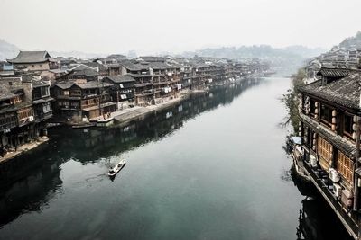 Boat in river along built structures