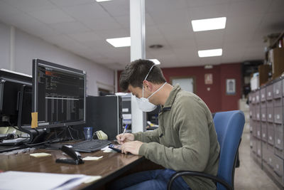 Man using mobile phone while sitting on table