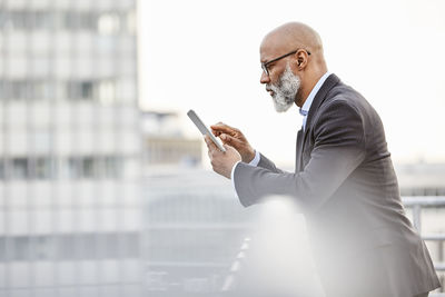 Businessman using digital tablet on rooftop