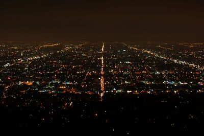 Illuminated cityscape against sky at night