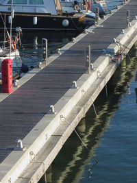 Boats moored at harbor against sky