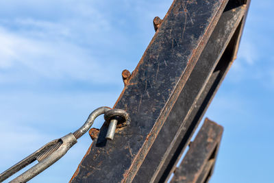 Low angle view of rusty metal against sky