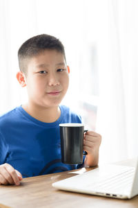 Close-up of boy on table at home