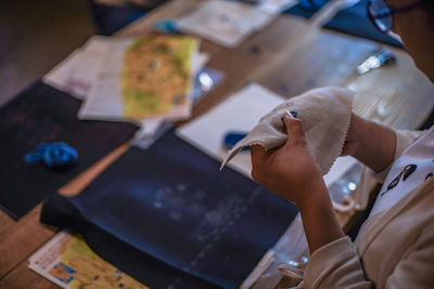 Midsection of woman making embroidery on fabric