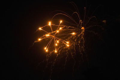 Low angle view of firework display at night