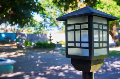 Close-up of telephone booth against trees in city