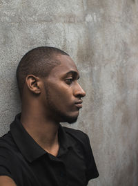 Thoughtful young man against wall