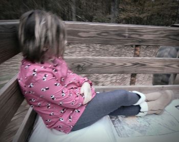 Rear view of woman sitting on bench