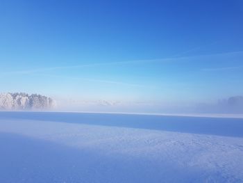 Scenic view of snow against clear blue sky