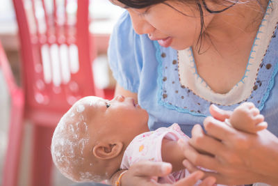 Close-up of woman feeding toddler son at home