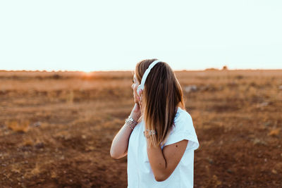 Woman standing on field against clear sky