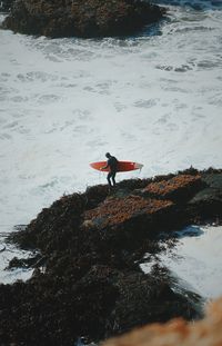 Man on rock at beach