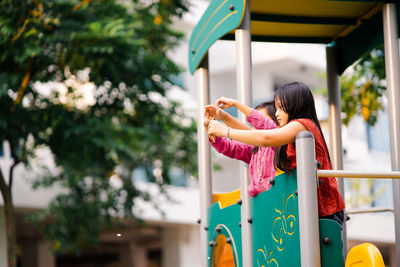 Side view of friends playing in playground