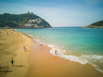 People on beach against sky