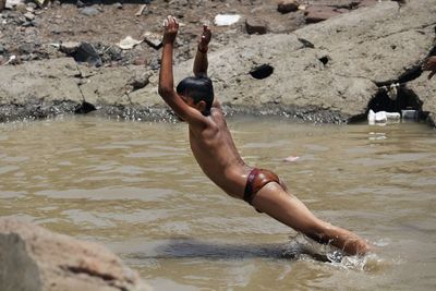 Full length of shirtless man in lake