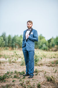 Portrait of young man standing on field