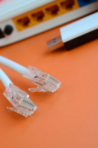 High angle view of network connection plugs on orange background