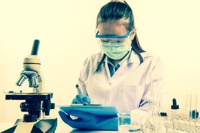 Female scientist writing on clipboard