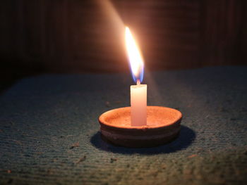 Close-up of burning candle on table