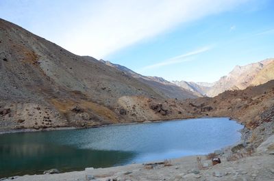 Scenic view of lake by mountains against sky