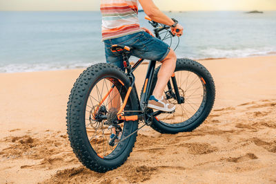 Fat bike on the beach with guy riding on it