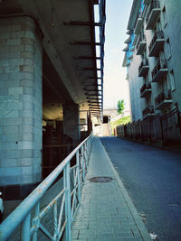 Walkway in city against sky